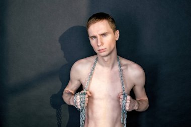 Zincir tutan yakışıklı sıska adam. Siyah arka plan