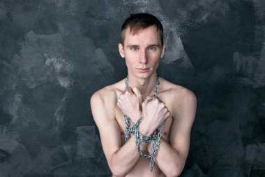 Zincir tutan yakışıklı sıska adam. Siyah arka plan