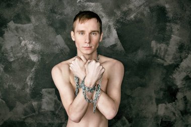 Zincir tutan yakışıklı sıska adam. Siyah arka plan