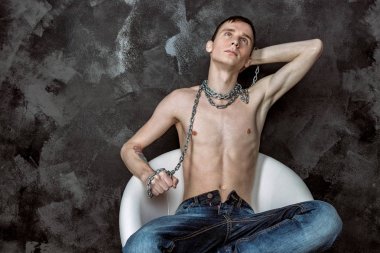 Zincir tutan yakışıklı sıska adam. Siyah arka plan