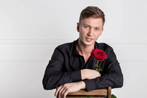 Stilig man bär svart skjorta håller en ros och få redo romantiskt datum — Stockfoto