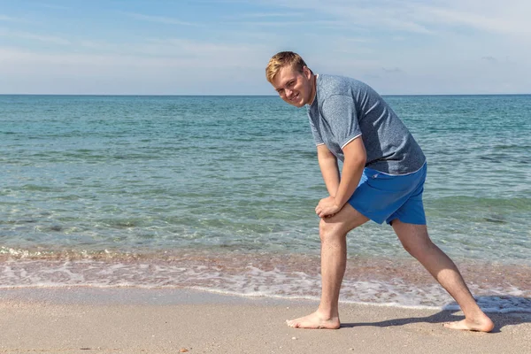 Hombre guapo haciendo ejercicio en la playa, entrenando al aire libre. Concepto de deporte y fitness —  Fotos de Stock