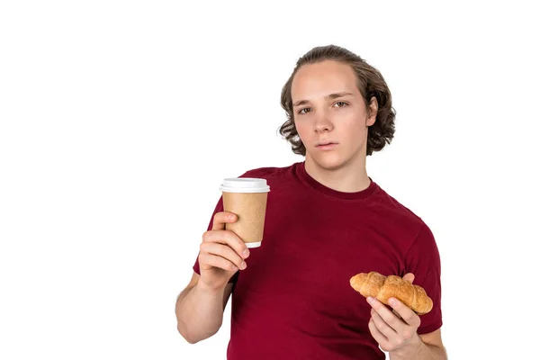 Jeune homme beau boire du café et manger croissant. Petit déjeuner français et café du matin. Isolé — Photo