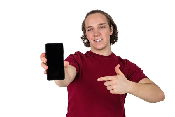 Красивий молодий чоловік у футболці тримає порожній смартфон на білому тлі — стокове фото