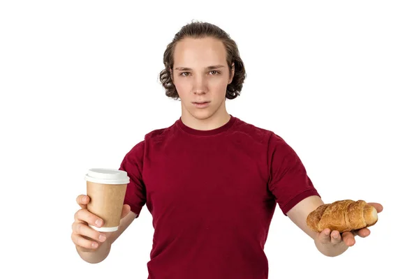 젊은 잘 생긴 남자는 커피를 마시고 크루아상을 먹는다. 프렌치 조식과 모닝 커피. 격리 — 스톡 사진