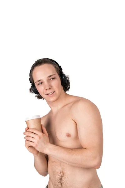 Knappe naakte jonge man in handdoek luisteren naar muziek in koptelefoon op witte achtergrond geïsoleerd — Stockfoto