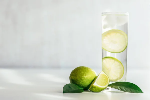 Vidro com água, gelo e fatias de limão — Fotografia de Stock