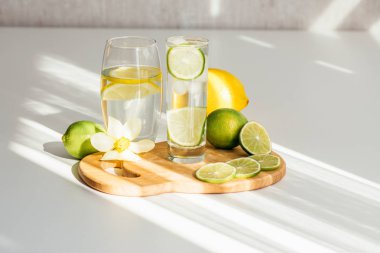 İki bardak su limon ve kireç bir ahşap tahta ve nergis çiçek 