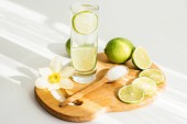 sklenici vody s citrónem na dřevěném prkénku a Narcis