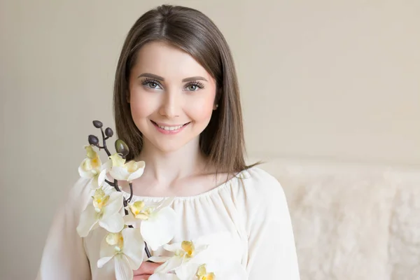 Hermosa chica sonriente con flor de orquídea — Foto de Stock