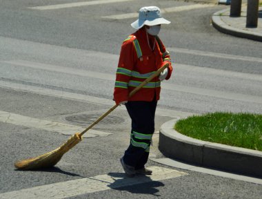 Temizlik süpürgesi ile turuncu kıyafeti sokak süpürme, Pekin, Çin 