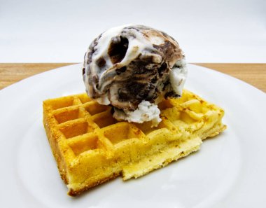 Beyaz çanak, ahşap masa, beyaz arka plan üzerinde dondurma ile lezzetli belçika waffle