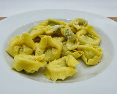 Beyaz çanak ricotta peyniri ve ıspanak ile Tortelloni