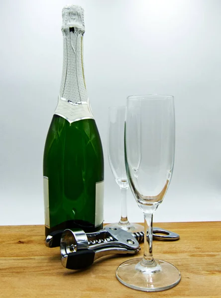 White sparkling wine, two glasses on wooden table, white background