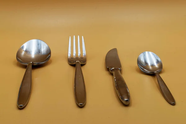 Spoon, knife, fork and teaspoon on an clear table, isolated on clear background