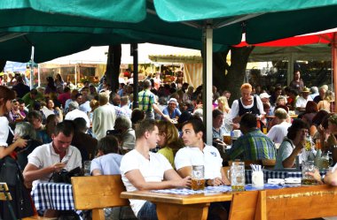Münih / Almanya - 22 Haziran 2011: Biergarten (bira bahçesi) Münih'in en ünlü bira salonudur. Biergarten her zaman bira içen turistlerle doludur ve Almanlar geleneksel Bavyera kostümleri giymiştir..