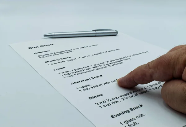 Checking and studying a diet chart, on white background.