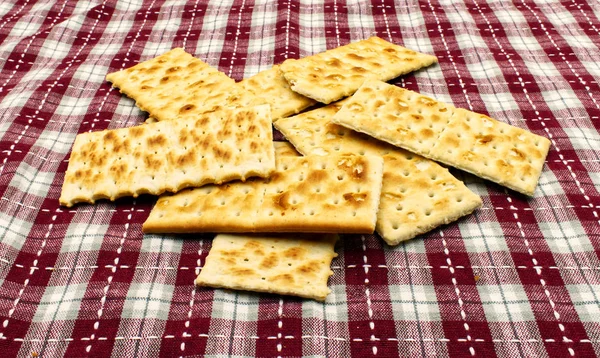 Breadsticks and crackers on a picnic table cloth