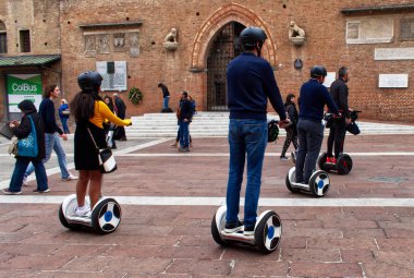 Bologna / İtalya - 12 Ekim 2019: Hoverboard elektrikli scooterlı turistler İtalya 'nın Bologna kentinin sokaklarını ziyaret ettiler.