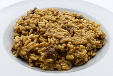 Beyaz arkaplanda izole edilmiş beyaz tabak üzerine risotto mantarı