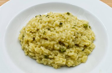 Beyaz tabakta kuşkonmazlı risotto.