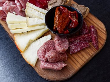 Tipik ürünler içeren Rustik Toskana tepsisi: prosciutto (jambon), kas, finocchiona, crostini, salam, tuscan chili ve dilimlenmiş pecorino peyniri. San Gimignano, Siena, İtalya 
