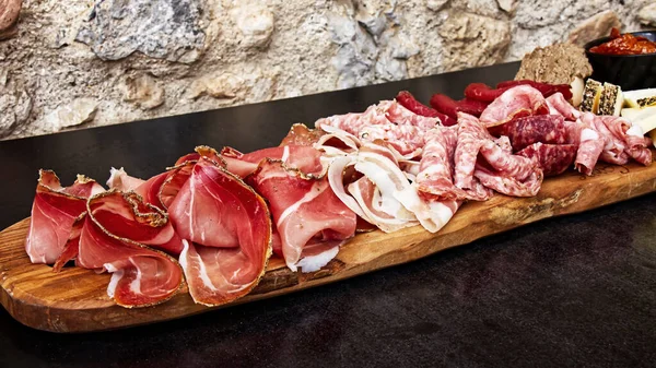 Tipik ürünler içeren Rustik Toskana tepsisi: prosciutto (jambon), kas, finocchiona, crostini, salam, tuscan chili ve dilimlenmiş pecorino peyniri. San Gimignano, Siena, İtalya 