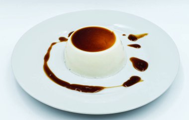 Beyaz tabakta karamel soslu Panna Cotta. Lezzetli İtalyan tatlısı.