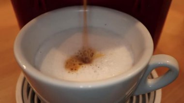 İtalyan kapuçinosundan yapılmış. Bir bar makinesinin yakın çekimi Cappuccino yapar
