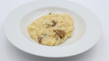 Beyaz arkaplanda izole edilmiş beyaz tabak üzerine risotto mantarı