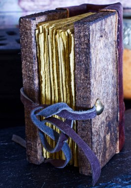 Tahta kapaklı ve sarı çarşaflı eski bir kitap. 