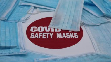 Kırmızı uyarı levhasının üzerine düşen tıbbi koruyucu maskeler: 19 Güvenlik Maskesi