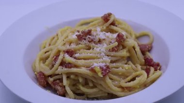 Kızarmış domuz pastırmalı ve pecorino romano peynirli, biberli, beyaz bir tabakta servis edilen geleneksel İtalyan usulü kremalı makarna.. 