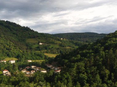Ardeche 'de bulutlu gökyüzü ve ormanlı güzel bir manzara.