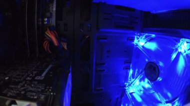 Mavi ışıklı bilgisayar vantilatörü çalışıyor. Bilgisayar sistemi soğutuluyor.