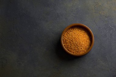 Koyu arkaplanda pişmemiş mercimek.