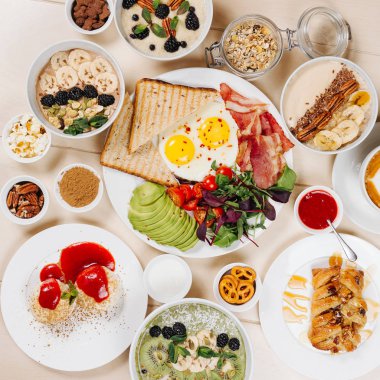 Sağlıklı kahvaltı, sabah lapası, muz, tarçın, yulaf ezmesi, kahve, süt, çırpılmış yumurta, peynirli kek, fındık, çilek