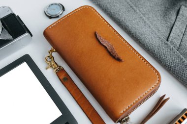 Beyaz arka planda ceket ve e-kitap ile deri eşyalar