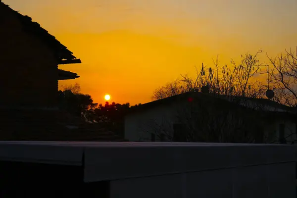 Восхищайтесь Окна Дома Красивым Закатом Который Окрашивает Небо Интенсивного Апельсина — стоковое фото
