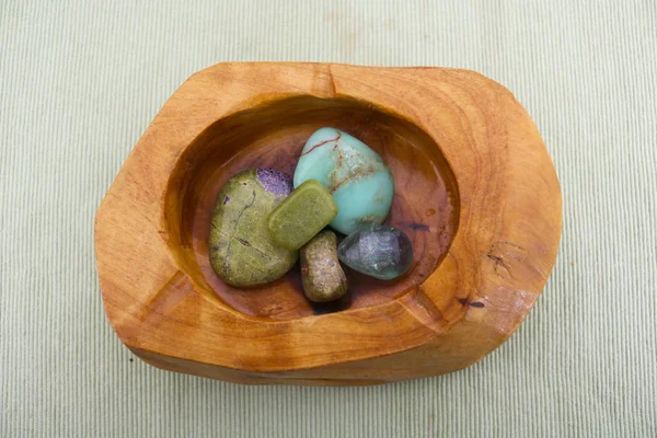 Chrysoprase, green precious stones inside a wooden container viewed from above, collectors items