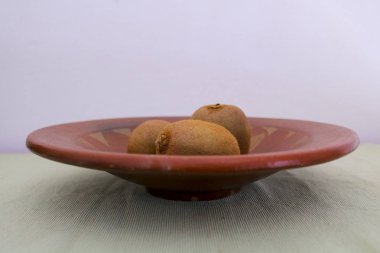 Bir seramik tabak, gıda ve mutfak içinde üç kivi