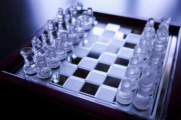 Close-up of a glass chess board with all the pieces, games of society and logic