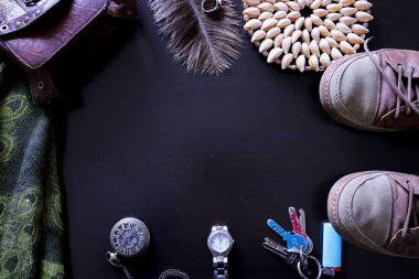 Yukarıdan görülen siyah bir arka plan üzerinde seyahat ve tatil nesnelerinin bileşimi