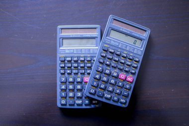 Siyah arkaplan görünümünde iki hesap makinesi, ofis nesneleri