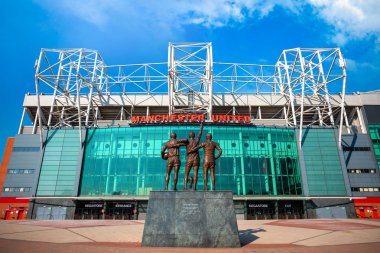 MANCHESTER, UK - MAY 19 2018: The United Trinity bronze sculpture which composed with George Best, Denis Law and Sir Bobby Charlton in front of Old Trafford stadium