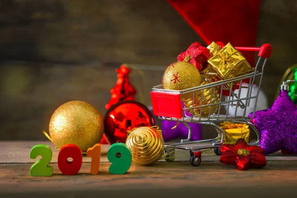 クリスマスと新年の背景の装飾とショッピングカートのミニチュア — ストック写真