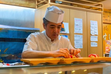 Tokyo, Japonya - 26 Nisan 2018: Tanımlanamayan Japon Suşi şefi bir restoranda geleneksel Japon Suşi kümelerinin yemekleri hazırlar