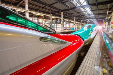 Iwate , Japan - April 22 2018: Japanese Shinkansen high speed train Hayabusa (green) and Komachi (red) join together at Kitakami Station travel up north east of Japan from Tokyo clipart