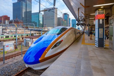 Japanese Shinkansen high speed train at a train station clipart