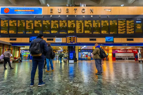 Люди ждут поезда на станции Юстон в Лондоне, Великобритания — стоковое фото